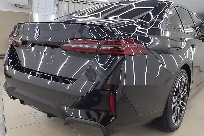 Juodas BMW i5 iš galo studijos apšvietime