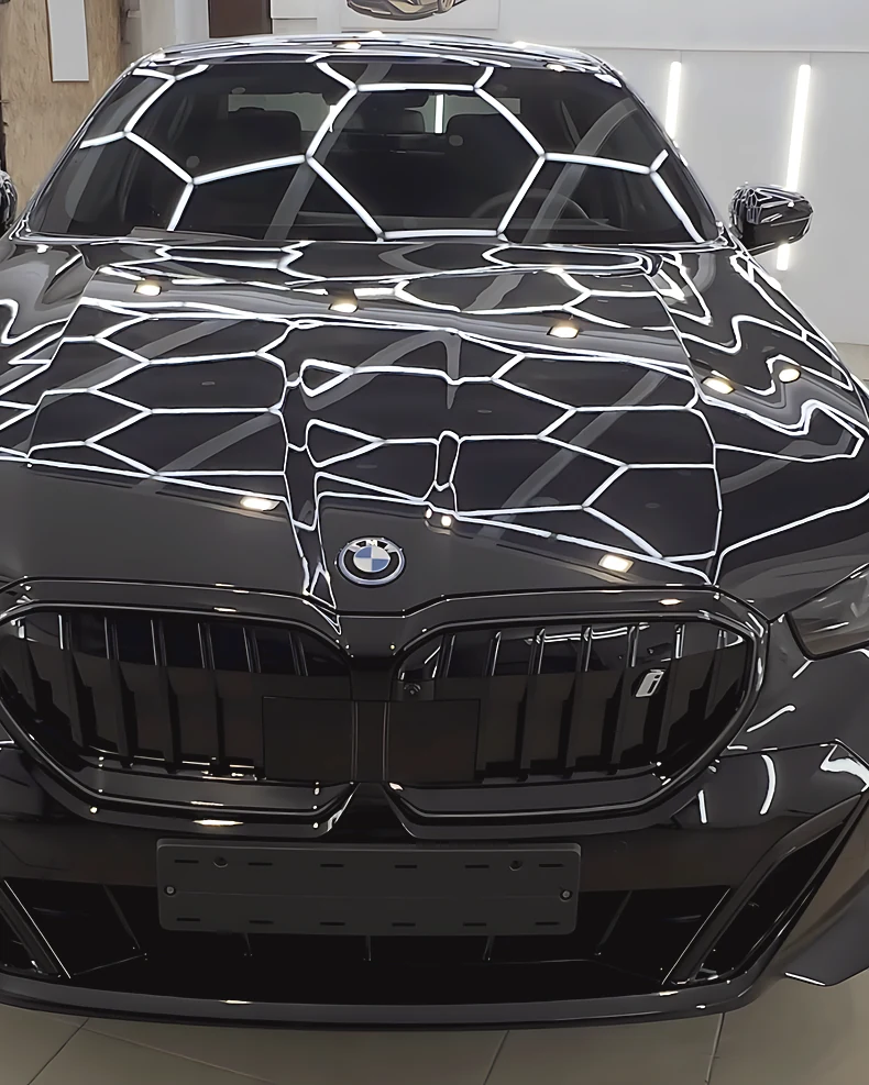 Juodo BMW i5 kapotas su šešiakampio apšvietimo atspindžiais studijoje